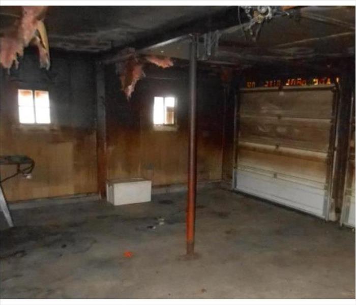 garage blackened by fire, hanging insulation damage door