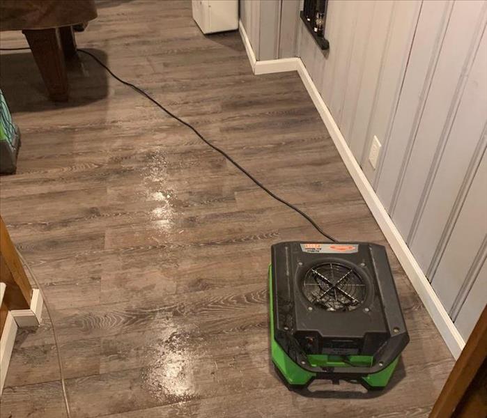 air mover drying out wet hardwood floor in gameroom
