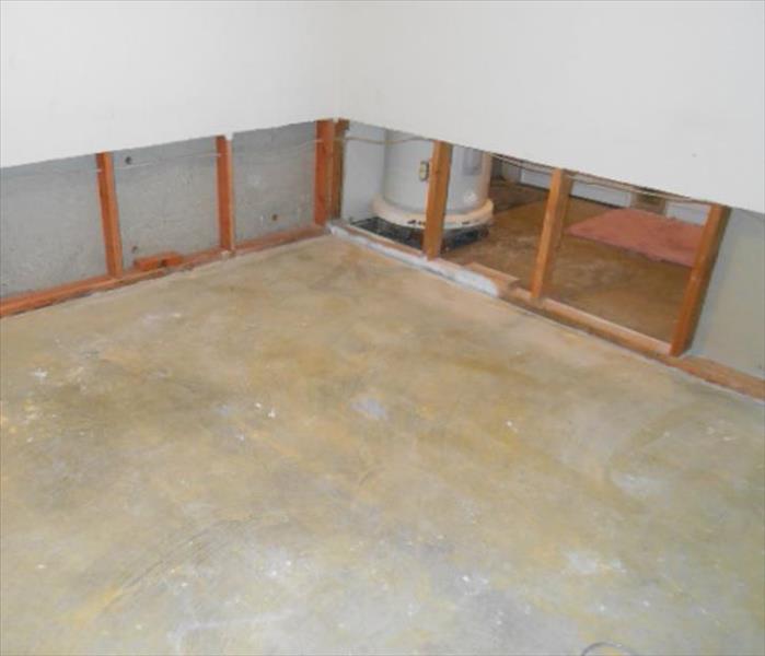 the visible concrete floor pad, water heater, and cut and removed lower wall sections