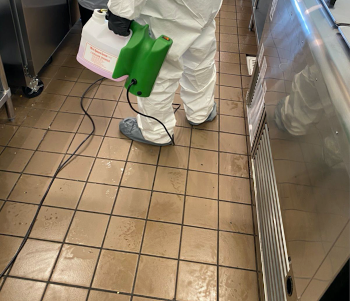 SERVPRO tech in PPE on tile floor in kitchen