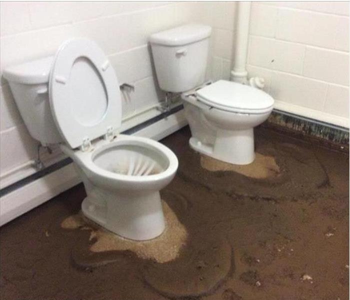 filthy, sewage on floor by two toilets