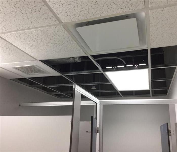 The drop ceiling is cleared of damaged tiles, shows inset lighting