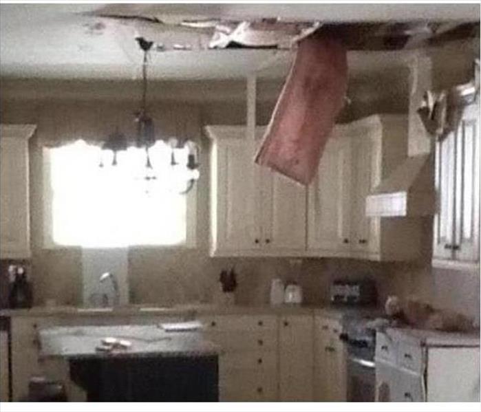 hanging insulation from a damaged ceiling in a kitchen
