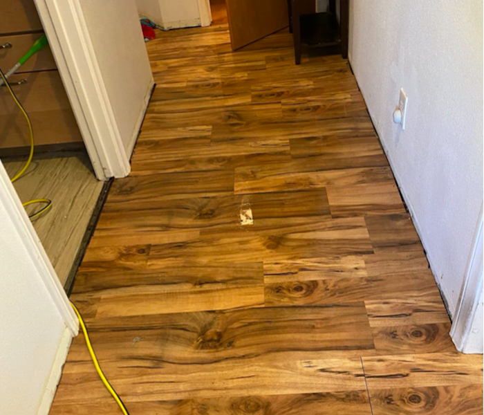 Hardwood floor with water and SERVPRO extraction equipment