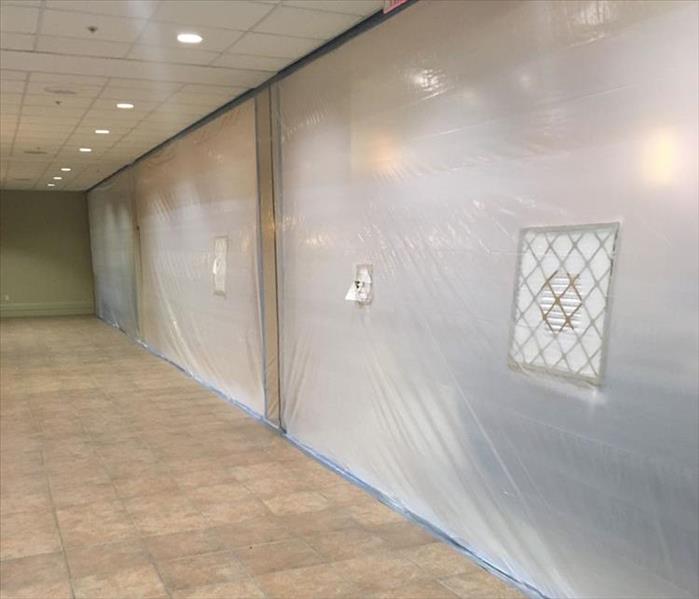 poly sheeting covering a wall in a commercial building, tiled floor
