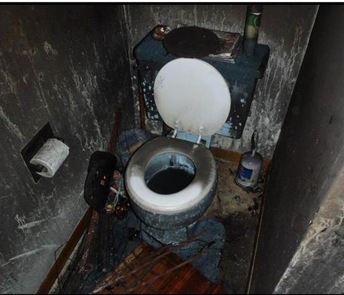 soot and fire damaged commode area in a house