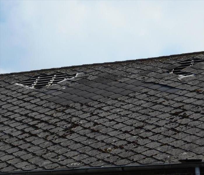 shingles missing off the roof of a house. 
